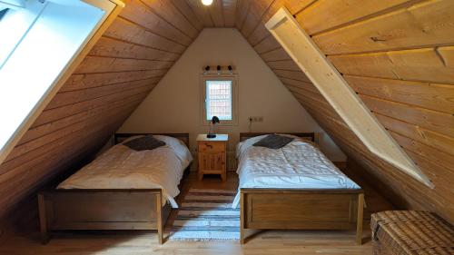 a attic room with two beds and a window at Feriendomizil Nordschwarzwald in Neuweiler