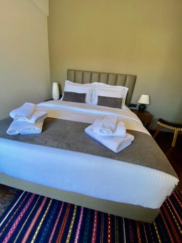 1 dormitorio con 1 cama con toallas en Monastiri Mountain Escape, en Konitsa