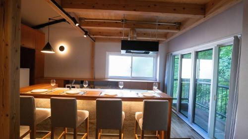 a kitchen with a large wooden table and chairs at Hotel Re:Plug in Kochi