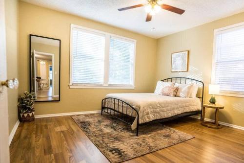 a bedroom with a bed with a fan and a mirror at Charming Riverside Retreat 1 1 - Near 5 Points #2 in Jacksonville