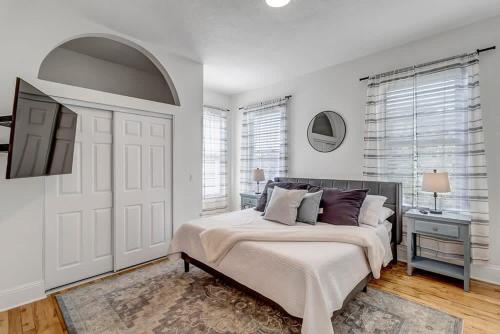 ein weißes Schlafzimmer mit einem Bett und einem TV in der Unterkunft Charming 1BR Apt in Historic Springfield in Jacksonville
