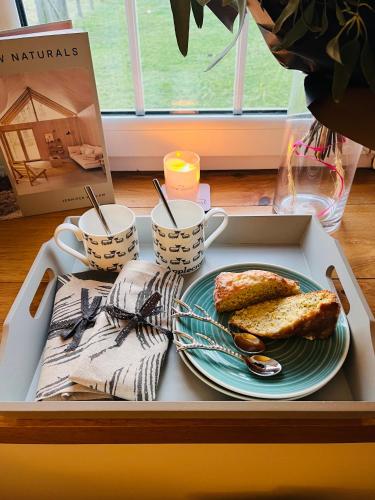 Clachan Manse Bed & Breakfast في أبليكروس: صينية مع صحن من الخبز المحمص وأكواب القهوة
