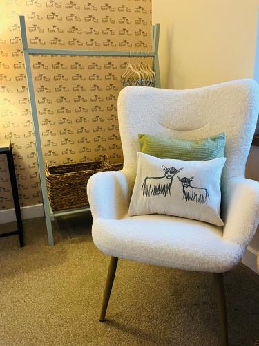 a white chair with a pillow on it at Clachan Manse Bed & Breakfast in Applecross