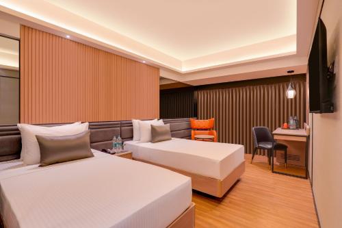 Habitación de hotel con 2 camas y escritorio en Lemon Tree Premier, Malad, Mumbai, en Bombay