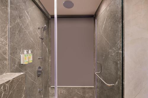 a shower with a glass door in a bathroom at Lemon Tree Premier, Malad, Mumbai in Mumbai