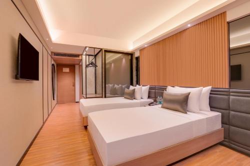 a hotel room with two beds and a television at Lemon Tree Premier, Malad, Mumbai in Mumbai