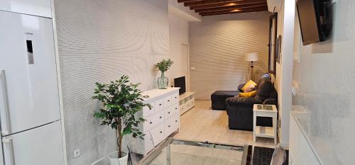 una sala de estar con una persona sentada en un sofá en Lujoso apartamento en la alameda, en Sevilla