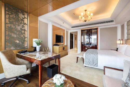 The Ritz-Carlton, Chengdu في تشنغدو: غرفة في الفندق مع سرير ومكتب