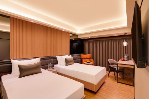 a hotel room with two beds and a desk at Lemon Tree Premier, Malad, Mumbai in Mumbai