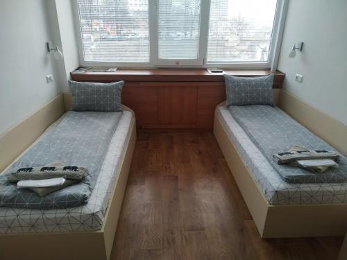 two beds in a room with two windows at Рачо Ковача in Gabrovo