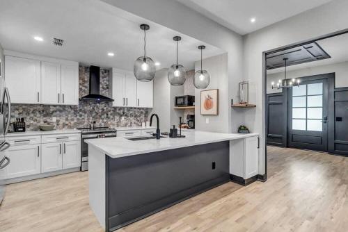 a large kitchen with white cabinets and a sink at Farmhouse chic in San Marco - 5 min to downtown in Jacksonville