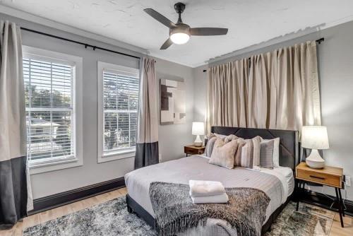 1 dormitorio con 1 cama, ventilador de techo y ventanas en Farmhouse chic in San Marco - 5 min to downtown, en Jacksonville