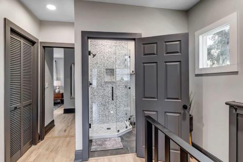 a bathroom with a walk in shower next to a door at Farmhouse chic in San Marco - 5 min to downtown in Jacksonville