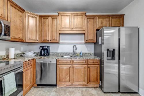 a kitchen with wooden cabinets and stainless steel appliances at Cozy Retreat - Walkable to Bars & Restaurants in Jacksonville