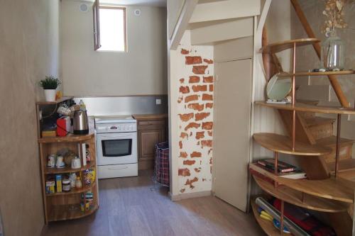 Il comprend une cuisine équipée d'une cuisinière et d'une étagère. dans l'établissement Maison de pêcheurs 2 chambres, proche de tout, à Trouville-sur-Mer