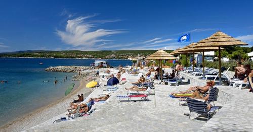 a group of people sitting on a beach at House Anita in Krk