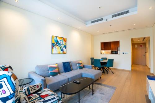 a living room with a couch and a table at RH- Modern Comfort, bright 1BR near Dubai Mall, City Views in Dubai