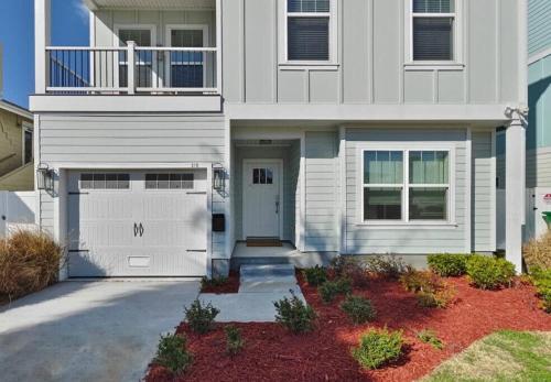 una casa blanca con una puerta y un garaje en Family Beach House with Pool - Blocks From Beach, en Jacksonville Beach