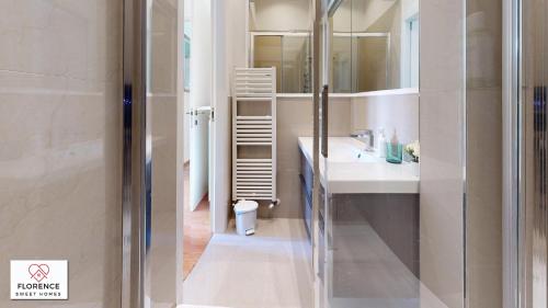 La salle de bains est pourvue d'une douche, d'un lavabo et d'un miroir. dans l'établissement Fortezza apartment, à Florence