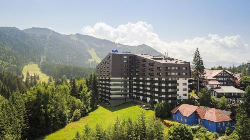 فندق منتجع ألبين في بويانا براسوف: مبنى على تل مع جبال في الخلفية