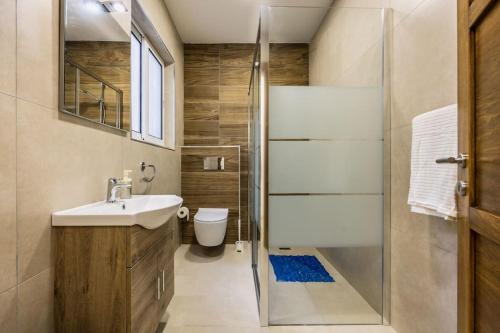 ein Bad mit einer Dusche, einem Waschbecken und einem WC in der Unterkunft Marsaskala 2 Bedroom Apartment in Marsaskala
