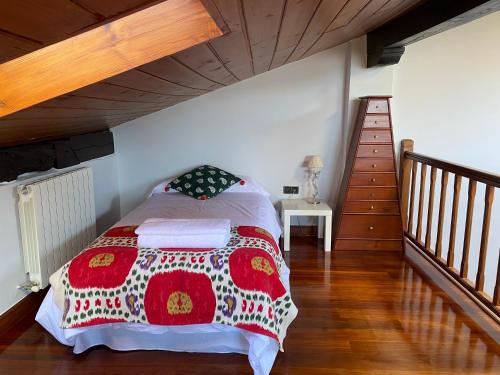 1 dormitorio con 1 cama y escalera de madera en Caserio Goitisolo - piscina jacuzzi climatizada, gimnasio y sauna en el corazón de la reserva de la biosfera de Urdaibai, en Gautegiz Arteaga
