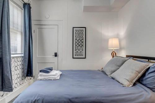a bedroom with a blue bed and a window at Contemporary Apartment - 5 Min To TIAA Bank Field! in Jacksonville