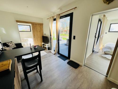 a living room with a table and a door to a bedroom at Villa Louméa - Le Loft avec jacuzzi in Friesenheim