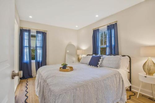 1 dormitorio con 1 cama grande y cortinas azules en Stylish + fresh bungalow 2 blocks from N-MC Stadium, en Annapolis