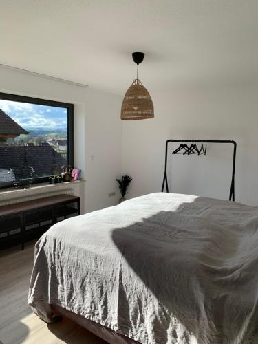 een slaapkamer met een bed en een raam met een piano bij Ruhig, Sonnig und etwas Speziell in Hilzingen