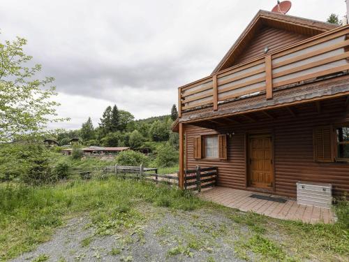 a log cabin with a wooden porch and a deck at Detached wooden chalet in Liebenfels Carinthia near the Simonh he ski area in Liebenfels