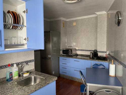 a kitchen with a sink and a refrigerator at Apartamento en Luis Montoto, Nervión. Céntrico in Seville