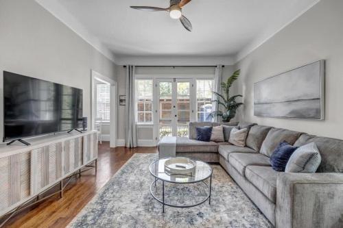 a living room with a couch and a flat screen tv at Renovated Apt - Blocks from Shoppes of Avondale in Jacksonville
