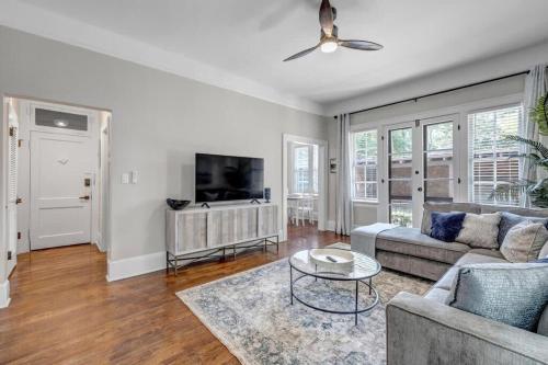 a living room with a couch and a tv at Renovated Apt - Blocks from Shoppes of Avondale in Jacksonville