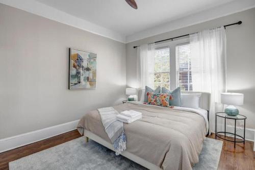 a white bedroom with a bed and a window at Renovated Apt - Blocks from Shoppes of Avondale in Jacksonville