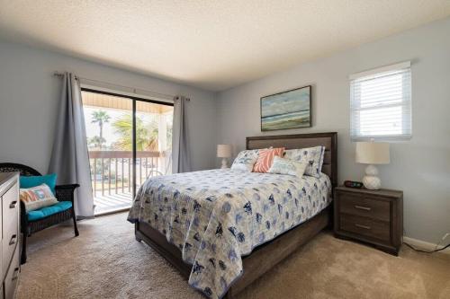 1 dormitorio con cama y ventana grande en TIDES BEACH PARADISE best served patch of beach, en Jacksonville Beach