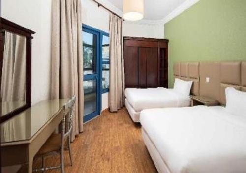 Pokój hotelowy z 2 łóżkami i biurkiem w obiekcie شقق الفخامة حي السلامة w mieście Dżudda
