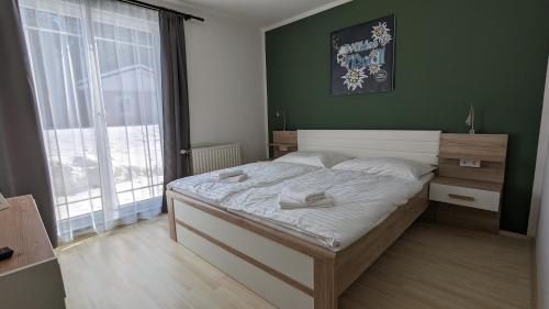 a bedroom with a large bed with a green wall at Wülde Hoamat in Eisenerz