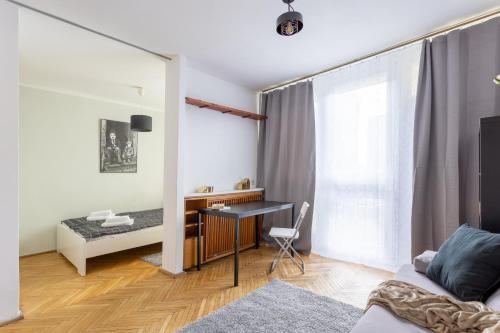 ein Wohnzimmer mit einem Schreibtisch und einem Sofa in der Unterkunft Golden Apartaments in Warsaw - One Bedroom Apartament in the center - Żelazna in Warschau