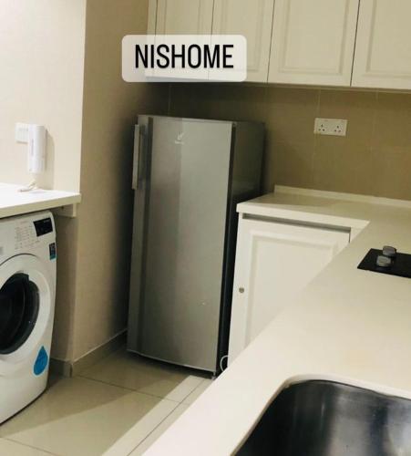 eine Küche mit einem Kühlschrank und einer Waschmaschine in der Unterkunft homestay icity isoho shahalam-Nishome in Shah Alam