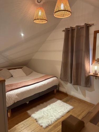 a room with a bed and two lamps and a rug at L’Escale du lac in Brêmes