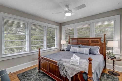 a bedroom with a wooden bed and windows at Stunning and Cozy 4BR in Historic Avondale in Jacksonville