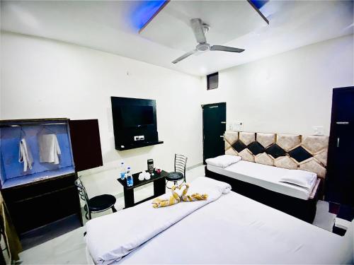 um quarto com duas camas e uma televisão na parede em swaran House em Amritsar