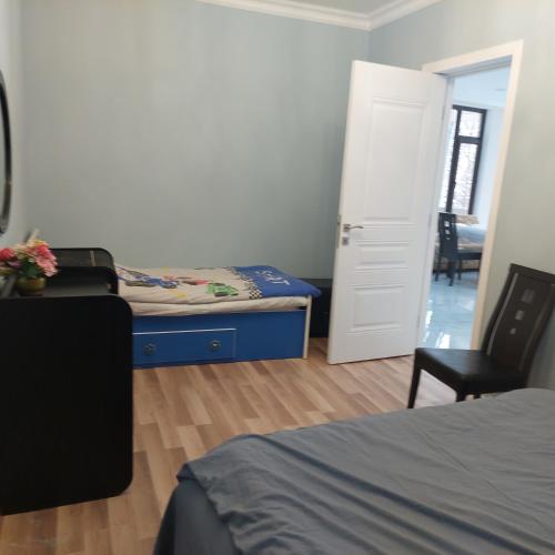 um quarto com uma cama, uma porta e uma cadeira em Home em Sheki
