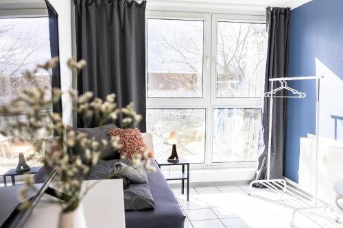 a living room with a couch and a large window at CosyHomes24 - Apartment with balcony and parking space - WIT01 in Witten