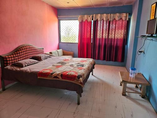 een slaapkamer met een bed, een tafel en een raam bij New Aashiyana Cottage in Matheran
