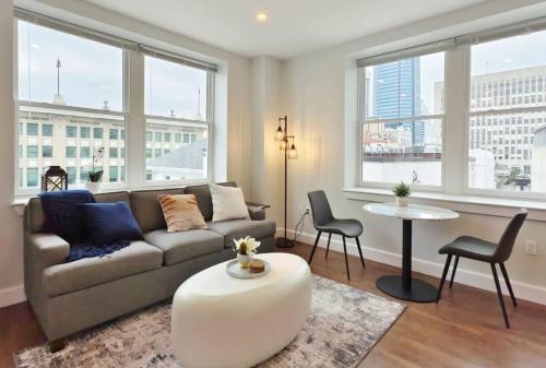 a living room with a couch and a table and windows at Fun Cozy Apts - 1 25 Mile Walk to TIAA Bnk Fld in Jacksonville