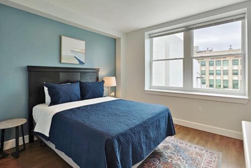 傑克孫維的住宿－Fun Cozy Apts - 1 25 Mile Walk to TIAA Bnk Fld，一间卧室设有蓝色的床和窗户。