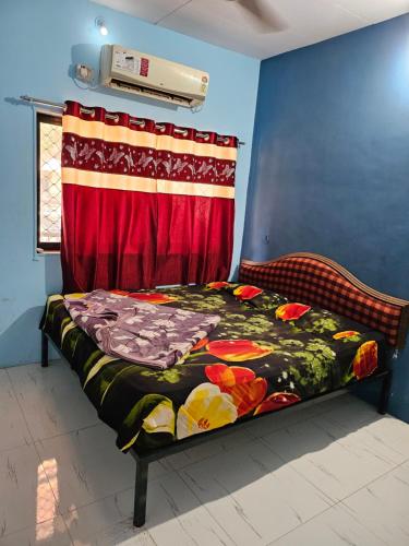 een bed in een kamer met een rood gordijn bij New Aashiyana Cottage in Matheran