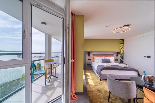a bedroom with a bed and a view of the ocean at Hotel Helikon, Keszthely in Keszthely